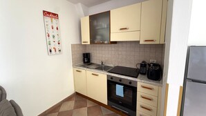 A kitchen with a stove, oven, sink, and a coffee maker. - Arias Giovanna Visa Lago Villa (Tremosine)