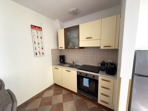 Eine Küche mit Herd, Backofen, Spüle und einer Kaffeemaschine.