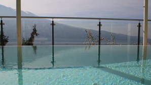 An indoor swimming pool with clear water, surrounded by glass walls. - Arias Giovanna Visa Lago Villa (Tremosine)