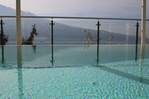 Ein Innenpool mit klarem Wasser, umgeben von Glaswänden.