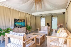 A room with a large tent-like ceiling, wooden furniture, a painting, and a television. - 2 bedrooms luxury glamping tent (Koh Samui)