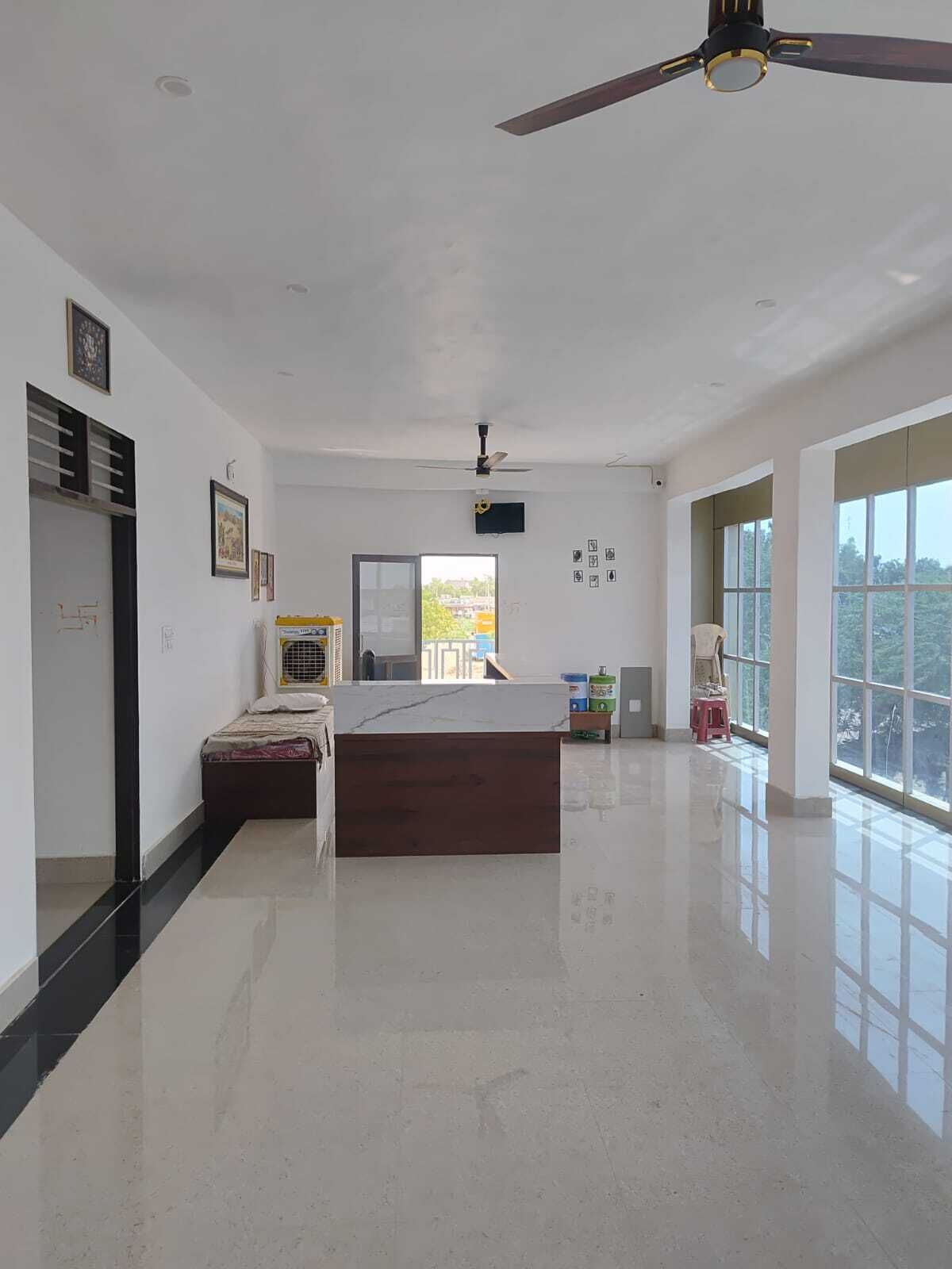 Una habitación amplia con una cama grande, ventilador de techo y vistas por la ventana.