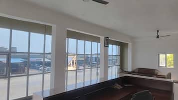 Una habitación con amplias ventanas, un escritorio, una silla y ventiladores de techo.