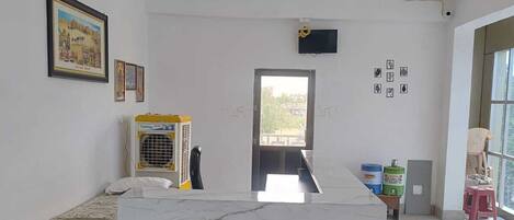 A room with a bed, a desk, a ceiling fan, and a window.