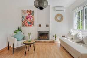 Ein modernes Wohnzimmer mit Kamin, einer Couch, einem Couchtisch und einem Bild an der Wand.