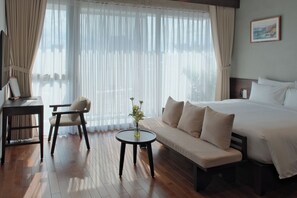 A hotel room with a bed, a sofa, a desk, and a chair. - Marisol Hotel (Da Nang)