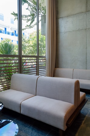 A modern interior with a sofa and a glass table. - Marisol Hotel (Da Nang)