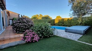 A backyard with a swimming pool, a patio area, and various shrubs. - Beautiful, air-conditioned villa for 6. Private pool, air conditioning, and private parking. (Sanary-sur-Mer)