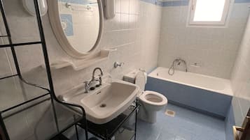 A bathroom with a sink, toilet, and bathtub.