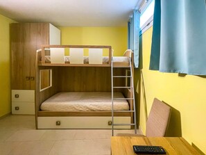 A bunk bed with a ladder, a desk with a chair, and a wardrobe in a room with yellow walls. - FranSea House - Otranto (Otranto)