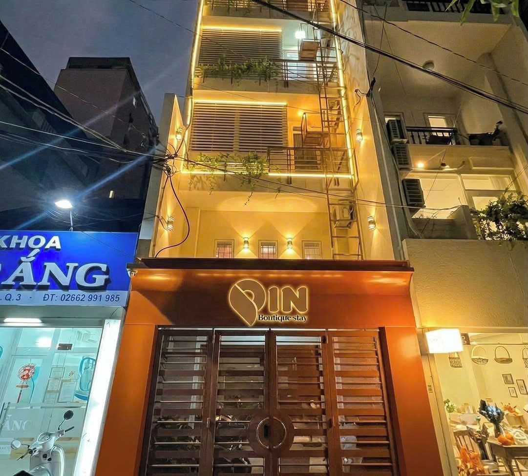 A building with a prominent 'IN Boutique stay' sign, a visible staircase, and a balcony with plants.