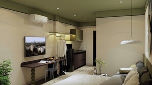 Una habitación de hotel moderna con escritorio, zona de estar, kitchenette y cama.