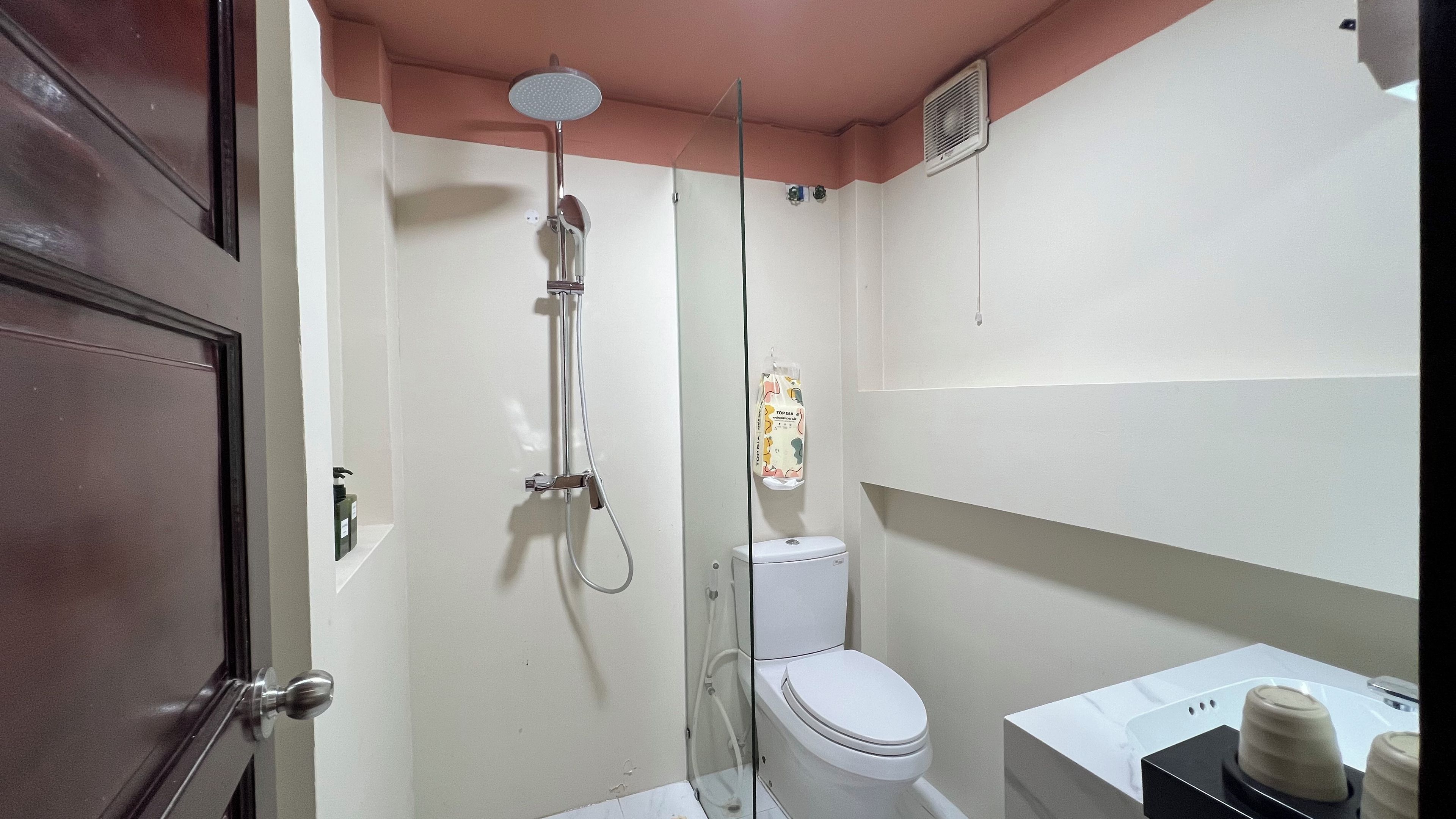 A bathroom with a shower, toilet, and sink.