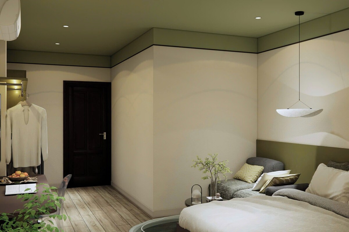 Een moderne slaapkamer met een bed, nachtkastje, lamp en uitzicht op de gang.