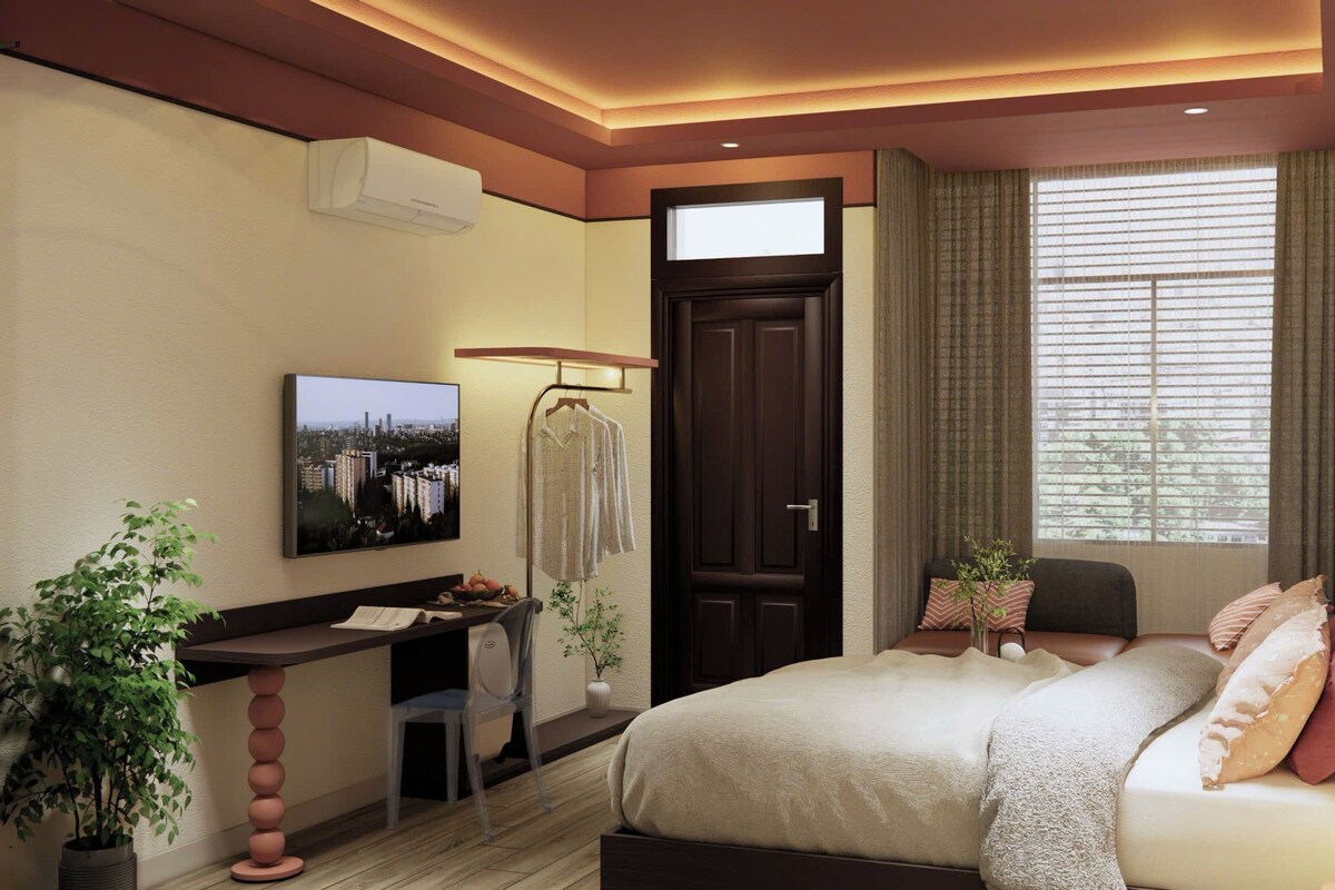 Een moderne slaapkamer met een bed, bureau en een televisie.