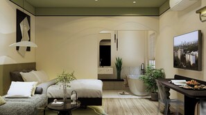 Una habitación de hotel moderna con cama, zona de estar y una bañera grande.