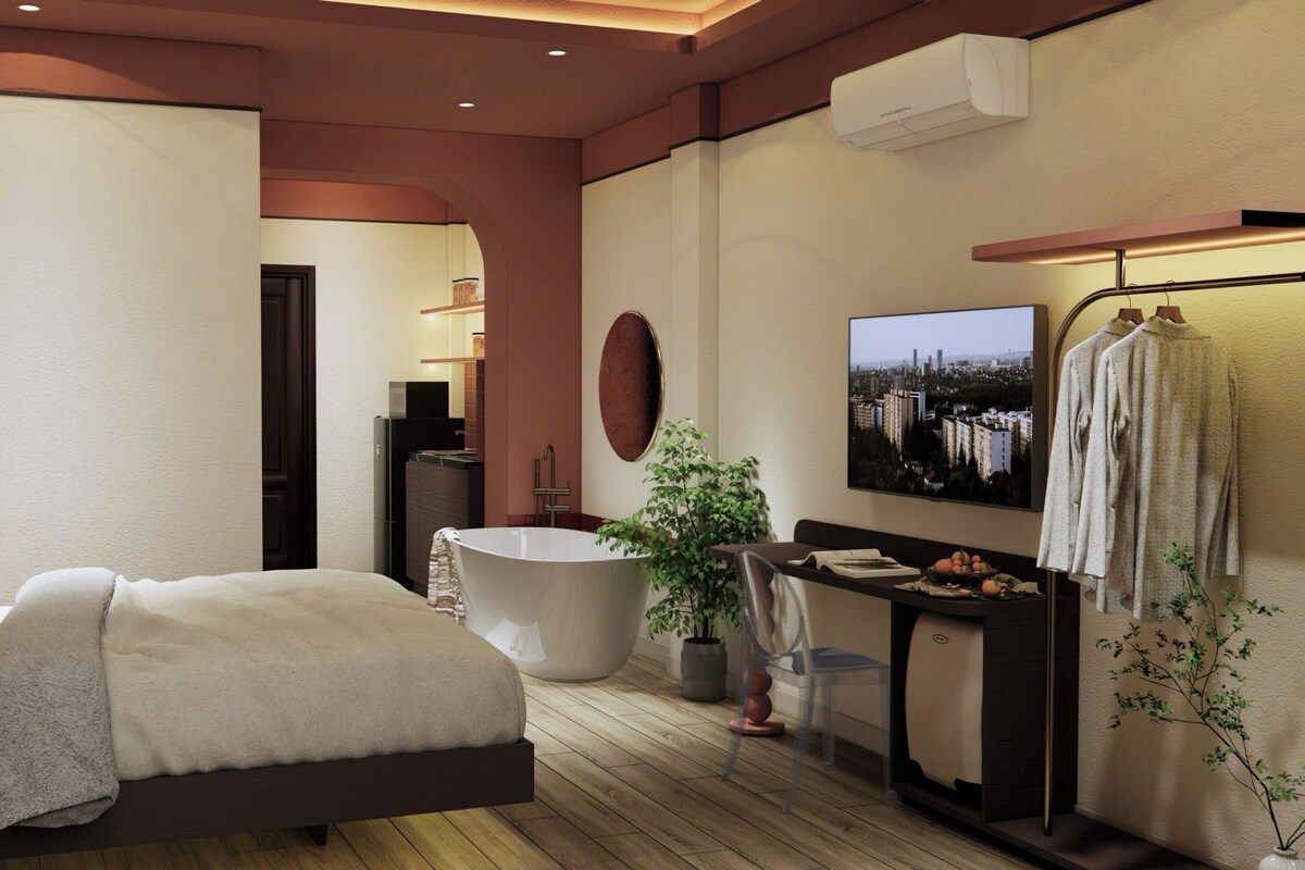 Een moderne slaapkamer met een groot bed, een badkuip, een kaptafel en uitzicht op de stad.