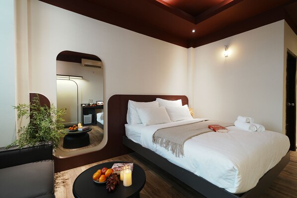 Una habitación de hotel con cama, mesita de noche y espejo.