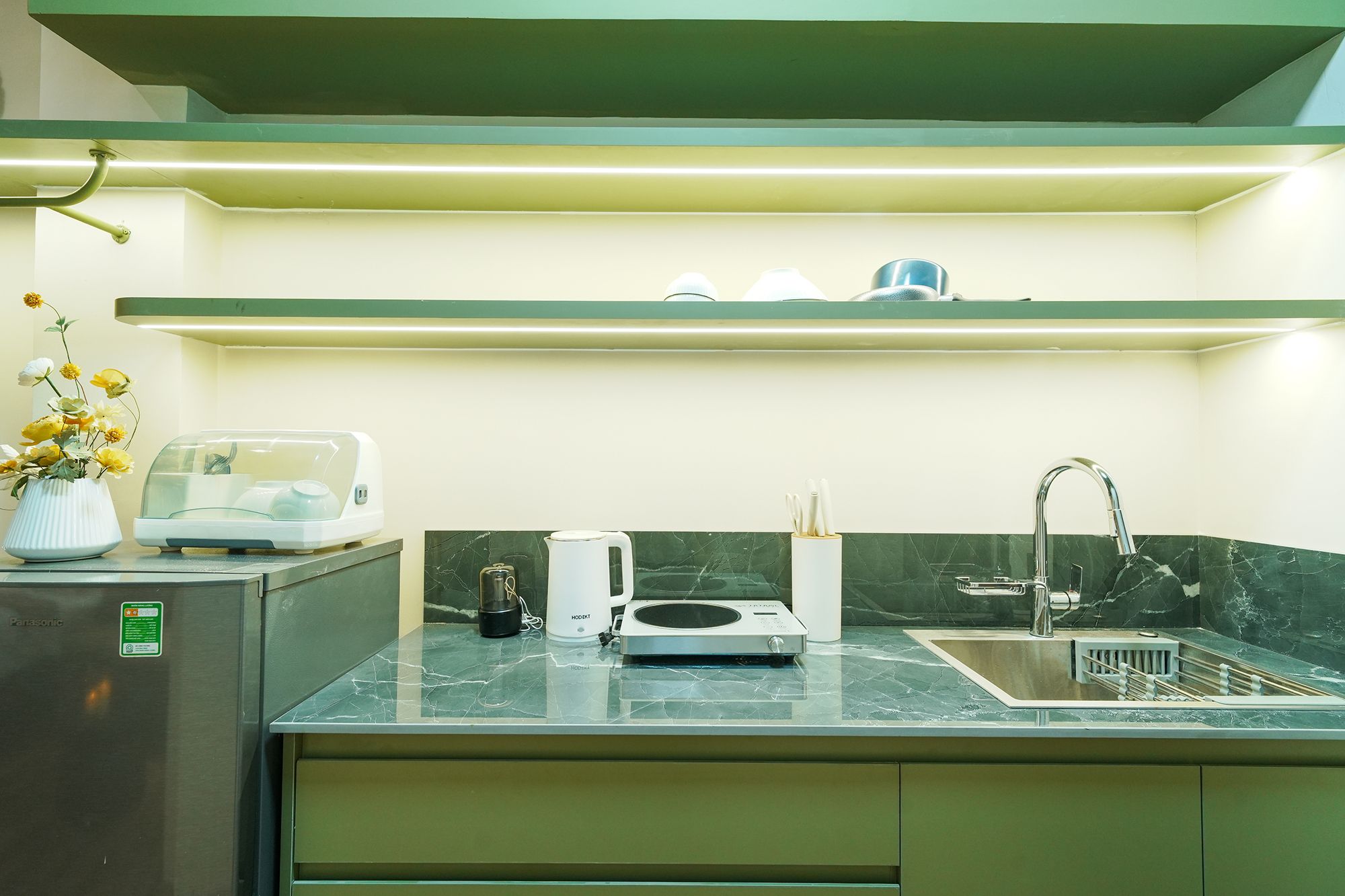 A modern kitchen with a built-in microwave, kettle, and coffee maker on the countertop.