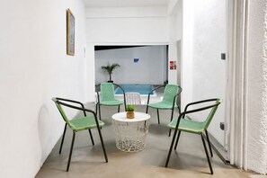 A narrow hallway with a white wall, a door on the right, and a small round table with a plant in the center. - Kardo Villa, 6 Bedrooms, Private Pool & Tropical Escape (Pointe-aux-Sables)