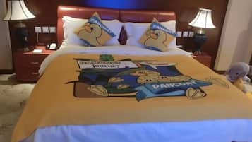 A hotel room with a bed, two nightstands, lamps, and a plush toy on the bed.