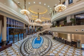 A grand hotel lobby with a central fountain, multiple levels, and a checkered floor pattern. - Cangzhou Bohai Hotel (Cangzhou)