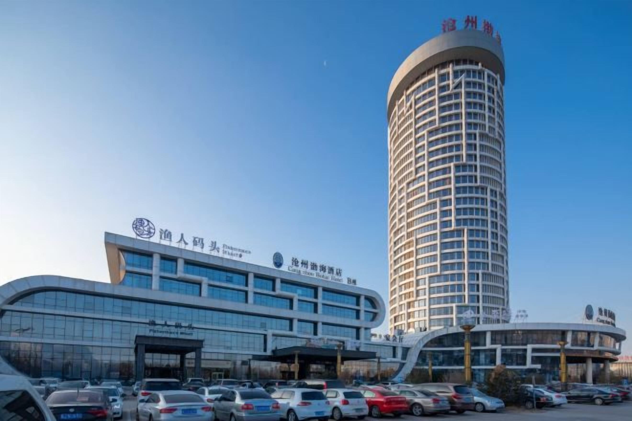 A hotel with a modern building and a tall cylindrical tower.