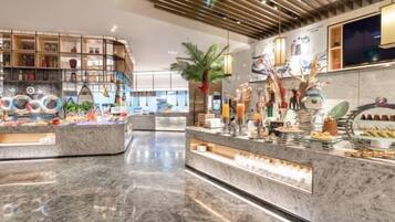 Un moderno vestíbulo de hotel con suelo de mármol, una recepción central y diversos elementos decorativos y plantas.
