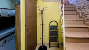 A staircase with a metal handrail, a coat rack, and a black radiator. - FranSea House (Otranto)