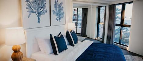 Een hotelkamer met een groot bed, een nachtkastje, een lamp en kunst aan de muur.