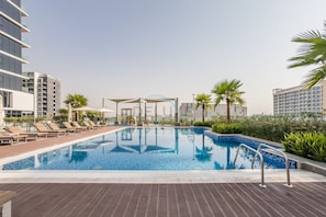 Ein Pool auf dem Dach mit Liegestühlen und einer überdachten Sitzgelegenheit.