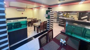 A restaurant with a counter, seating area, and a fish tank.
