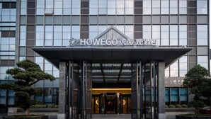 A hotel entrance with a modern facade, a covered entrance area, and a sign indicating the hotel name.