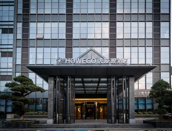 A hotel entrance with a modern facade, a covered entrance area, and a sign indicating the hotel name.