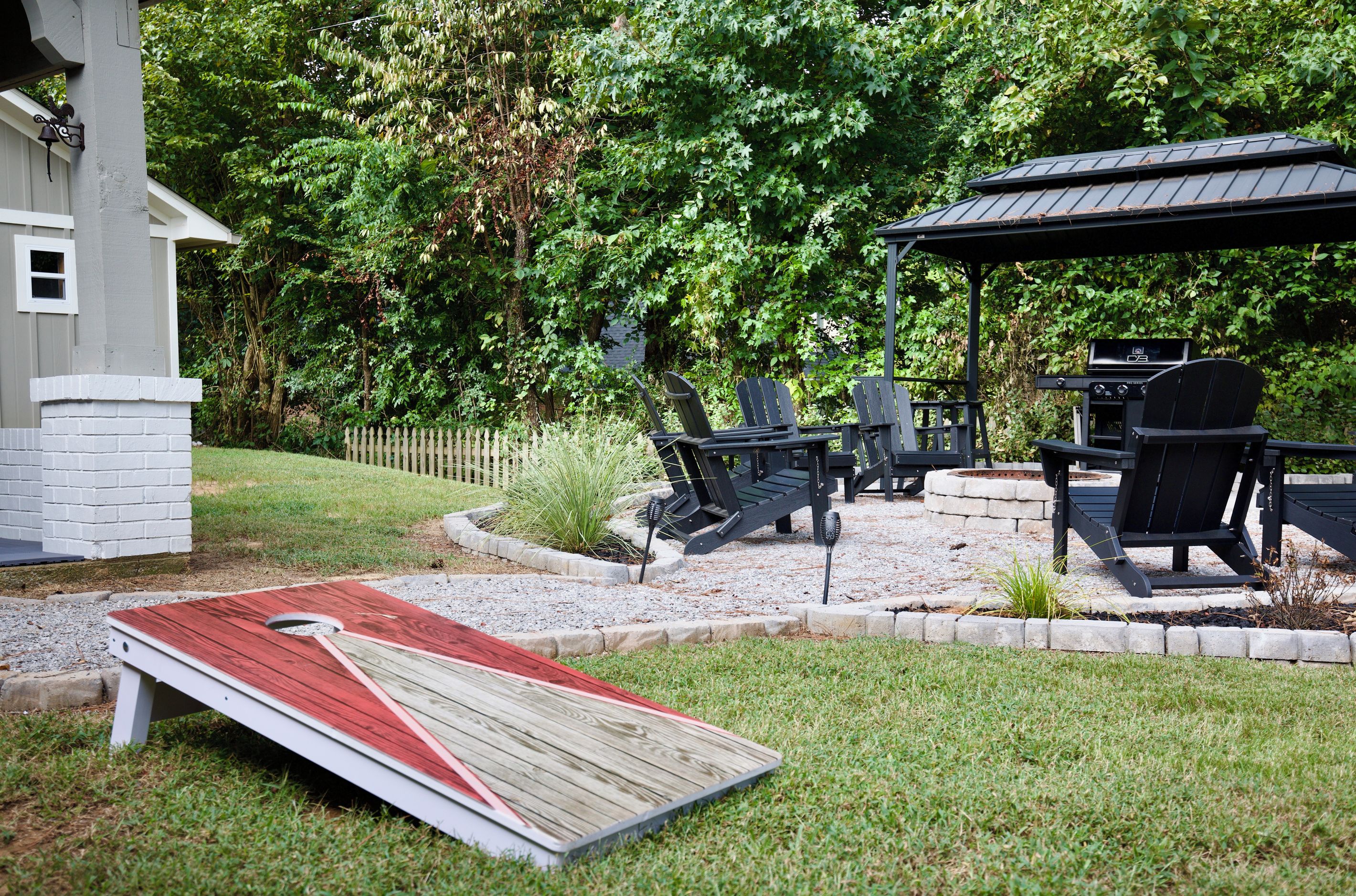Eine Terrasse mit Grill, Sitzgelegenheiten im Freien und einer kleinen Holzterrasse.