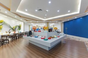 Una hall d'hotel moderna con una reception centrale, pavimento in legno e una parete di accento blu.