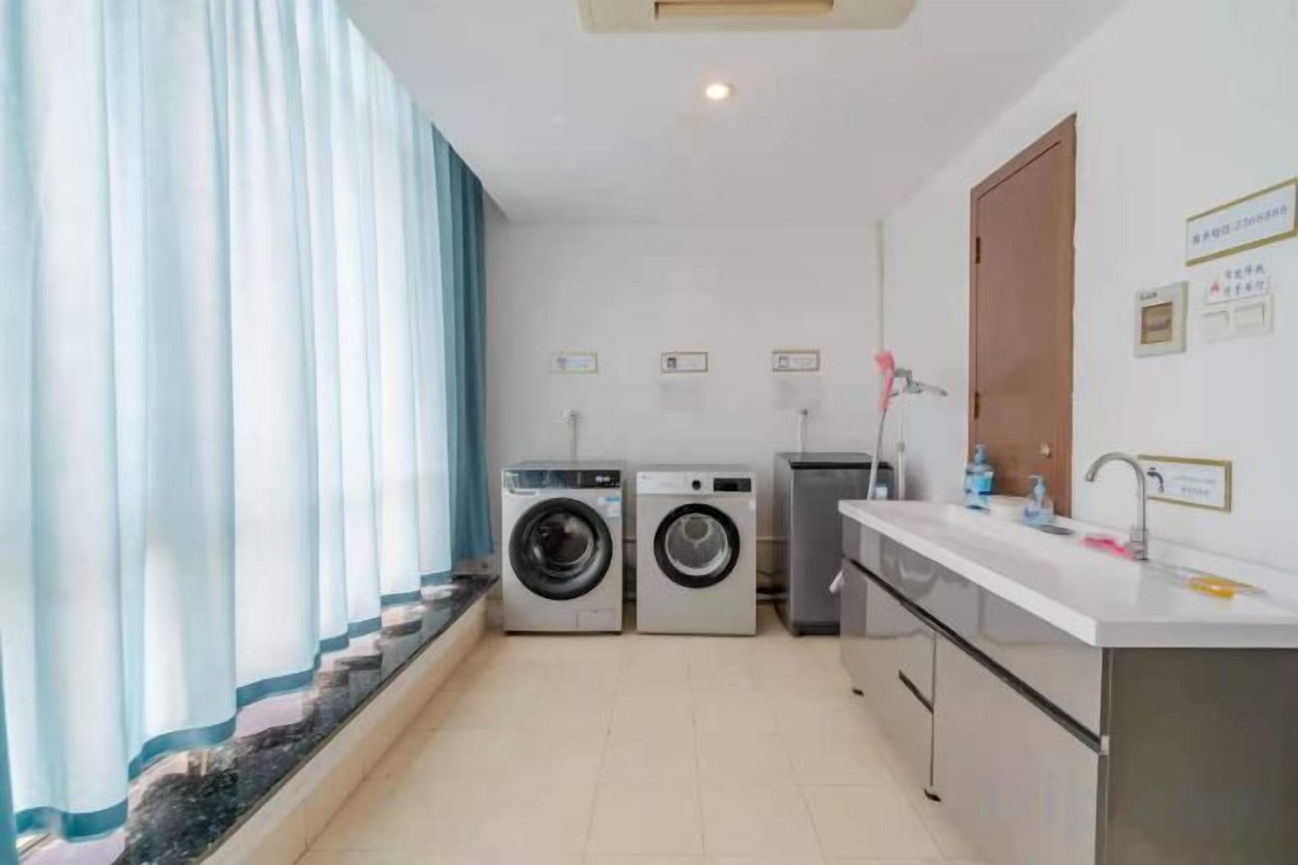 Un lavadero con lavadora, secadora y lavabo.