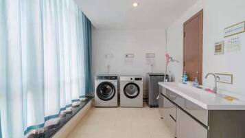 A laundry room with a washing machine, dryer, and a sink.