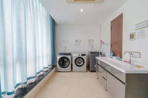 Un lavadero con lavadora, secadora y lavabo.