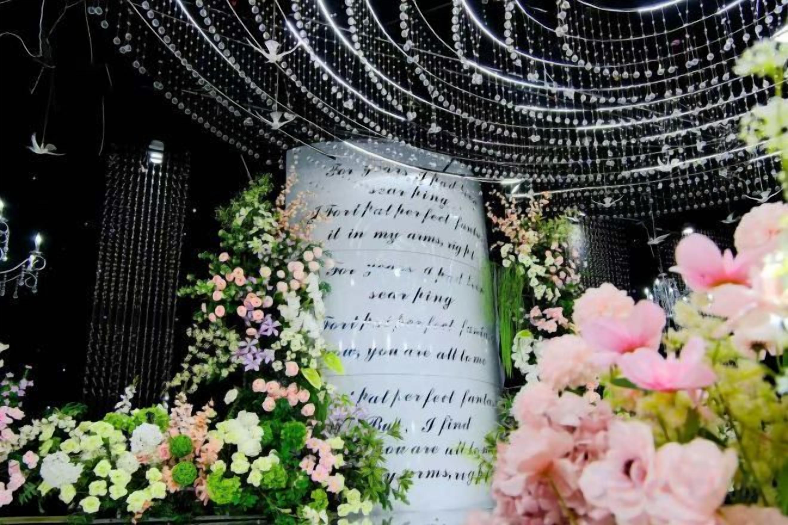 Una decoración con un libro abierto grande rodeado de flores.