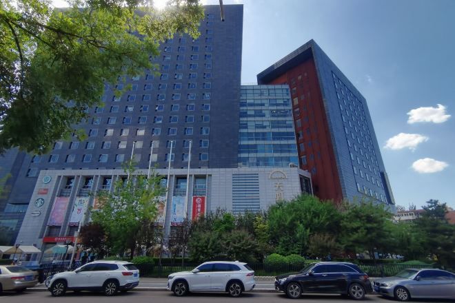 A multi-story building with a modern architectural design, featuring a mix of glass and concrete facades.