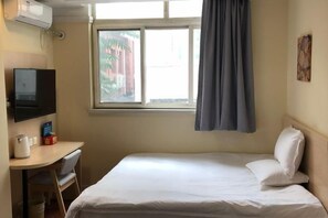 A hotel room with a bed, a desk with a chair, a television, and a window with curtains. - Elong ME Hotel (Beijing Zuojiazhuang) (Beijing)