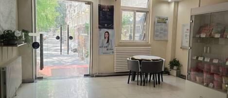 Un vestíbulo de hotel con una recepción, un área de espera y una máquina expendedora.