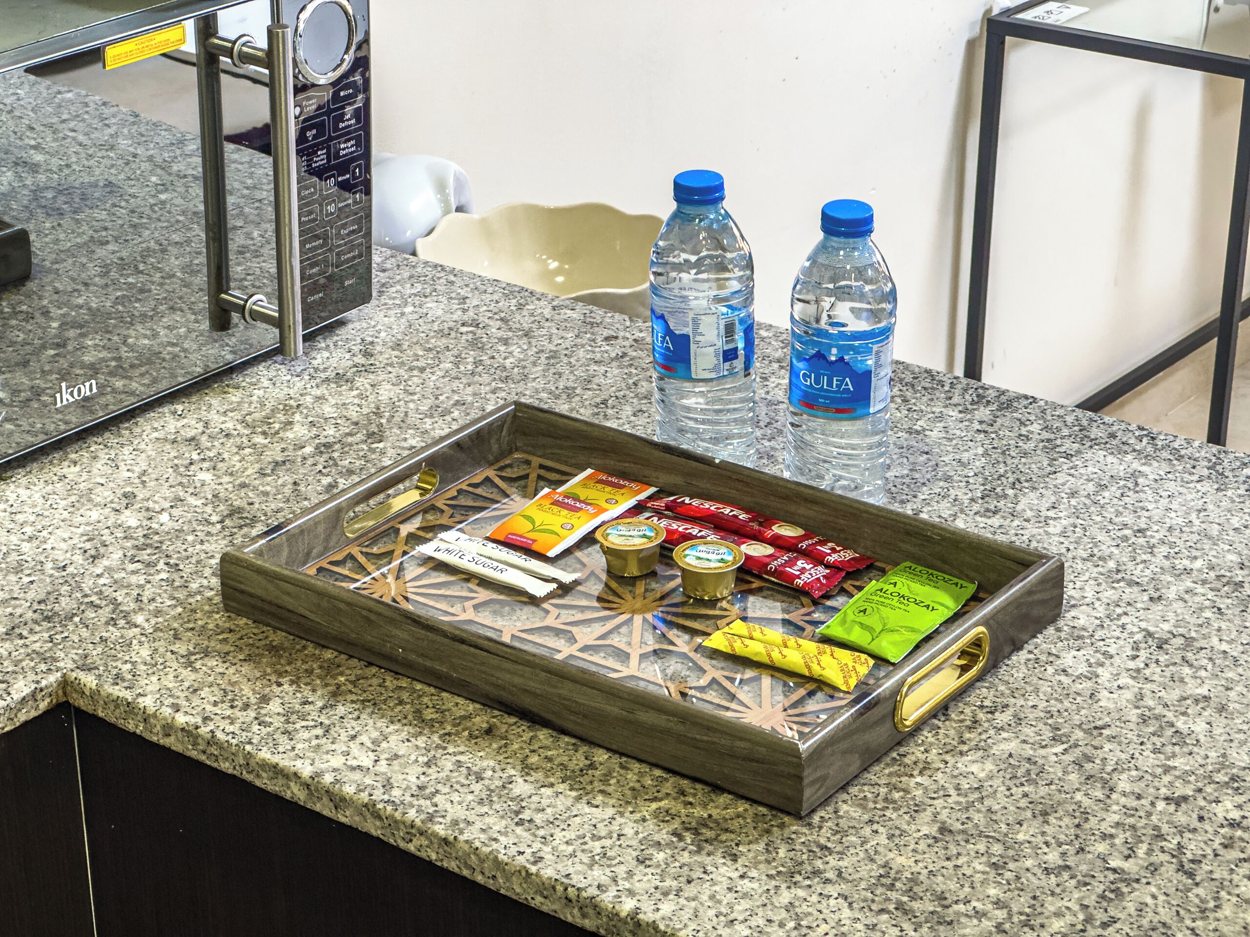 Una bandeja con aperitivos y botellas de agua sobre una encimera de granito.