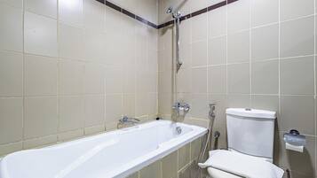 A bathroom with a bathtub, toilet, and shower.