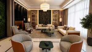 Una sala de estar moderna con chimenea, asientos cómodos y una lámpara decorativa.