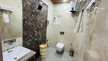 Un baño con pared de mármol, un lavabo, un inodoro y un bidé.