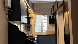 A modern kitchen with a built-in oven, a microwave, and a stove. There is a window providing natural light and a view of the outside.