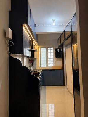 A modern kitchen with a built-in oven, a microwave, and a stove. There is a window providing natural light and a view of the outside.