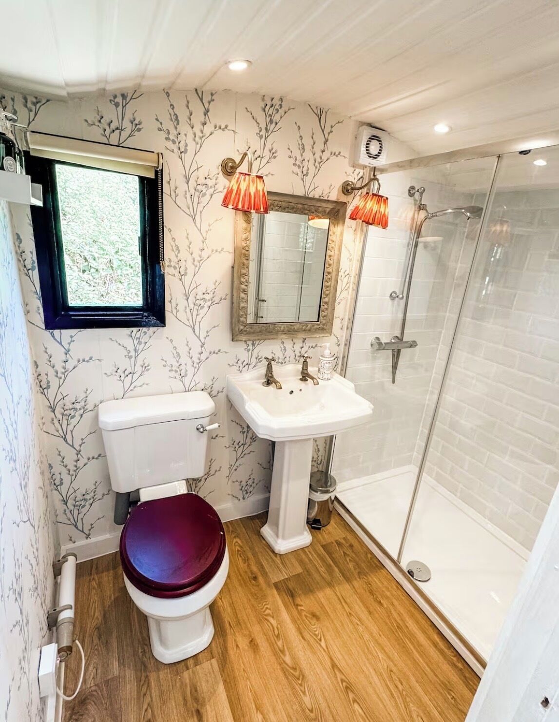 A bathroom with a toilet, sink, and shower.